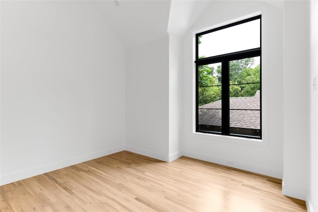 empty room with lofted ceiling and light wood-type flooring