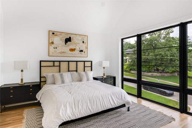 bedroom with lofted ceiling and light hardwood / wood-style flooring