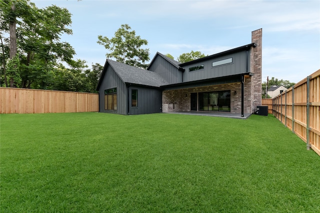 back of property featuring a shed, central AC unit, and a lawn