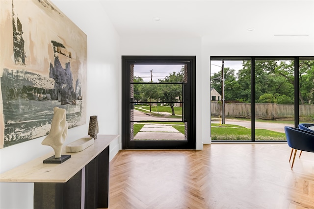 doorway with parquet flooring and a healthy amount of sunlight