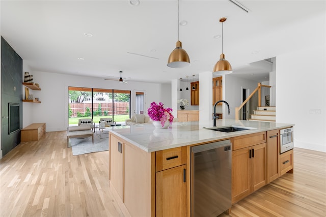 kitchen with light hardwood / wood-style flooring, a center island with sink, sink, pendant lighting, and appliances with stainless steel finishes