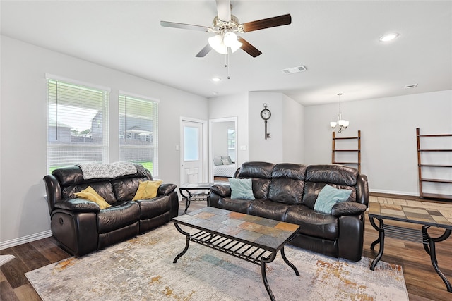 living room with dark hardwood / wood-style floors and ceiling fan with notable chandelier