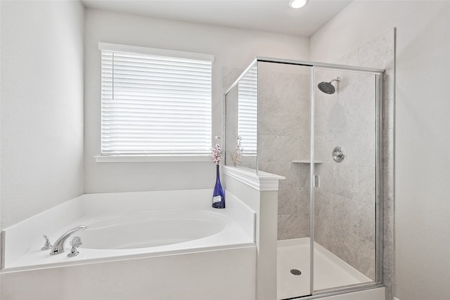 bathroom featuring independent shower and bath and a wealth of natural light