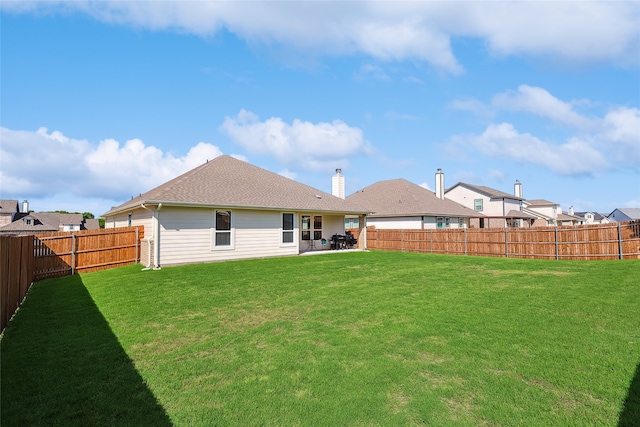 rear view of property with a patio and a lawn