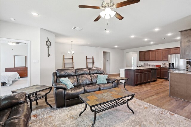 living room with light hardwood / wood-style flooring, sink, and ceiling fan