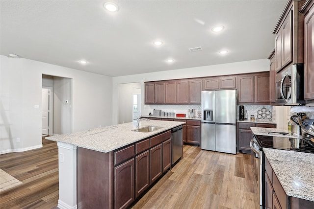 kitchen with light hardwood / wood-style floors, sink, tasteful backsplash, and stainless steel appliances