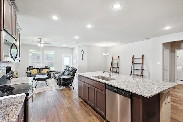 kitchen featuring dark brown cabinets, an island with sink, sink, appliances with stainless steel finishes, and light hardwood / wood-style flooring