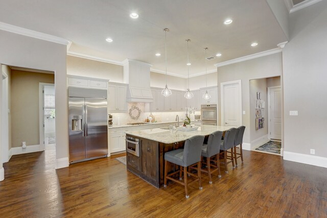 kitchen with pendant lighting, sink, an island with sink, and appliances with stainless steel finishes