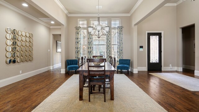 living room featuring hardwood / wood-style flooring, a fireplace, ornamental molding, and a towering ceiling