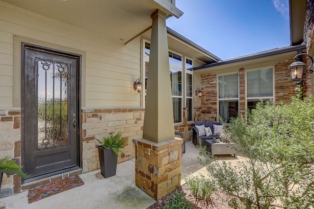 entrance to property featuring a patio and outdoor lounge area