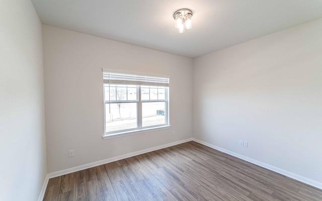 empty room featuring wood finished floors and baseboards