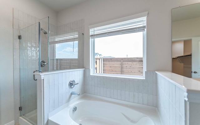 bathroom featuring a stall shower and a bath