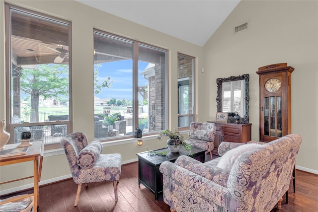 living room featuring a healthy amount of sunlight, vaulted ceiling, and dark hardwood / wood-style flooring