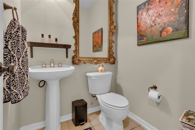 bathroom featuring tile flooring and toilet