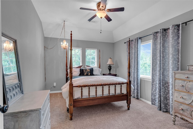 carpeted bedroom featuring vaulted ceiling and ceiling fan with notable chandelier