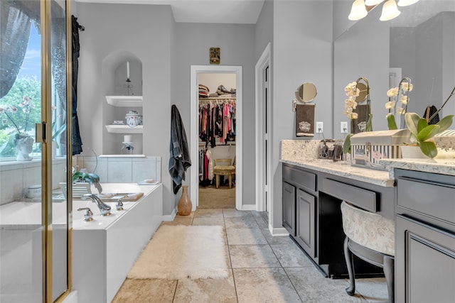 bathroom with tile floors, a washtub, and vanity