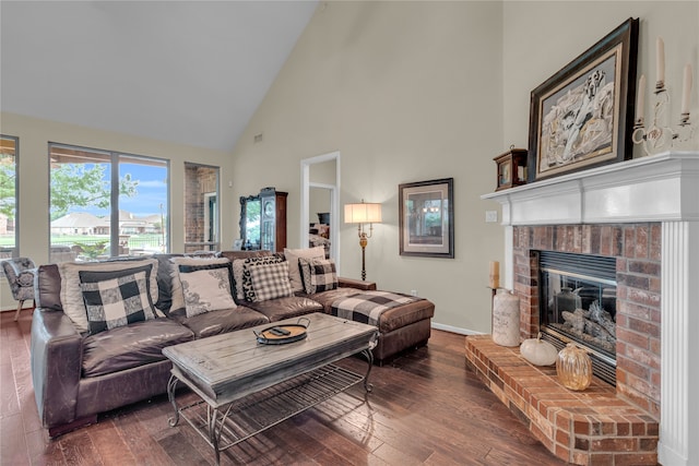 living room with dark hardwood / wood-style floors, high vaulted ceiling, and a brick fireplace