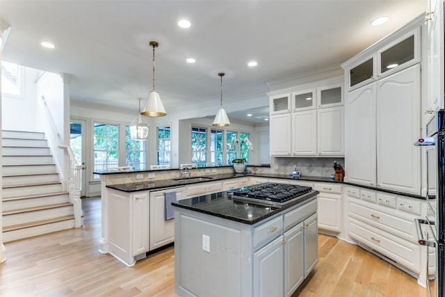 kitchen with light hardwood / wood-style floors, kitchen peninsula, and a kitchen island