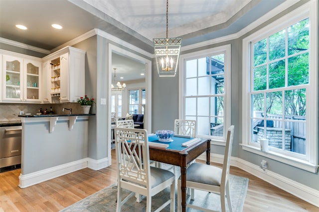 dining area featuring a notable chandelier, light hardwood / wood-style flooring, and a wealth of natural light