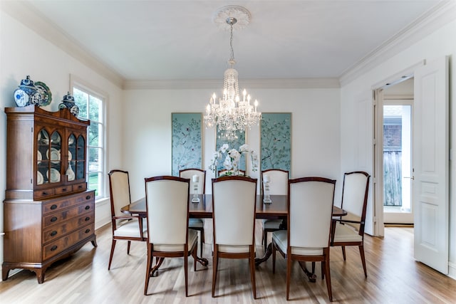 dining area with ornamental molding, an inviting chandelier, and hardwood / wood-style flooring