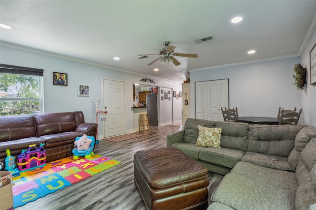 living room with ornamental molding, ceiling fan, and hardwood / wood-style flooring