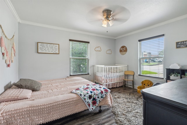 bedroom featuring multiple windows, crown molding, dark hardwood / wood-style flooring, and ceiling fan