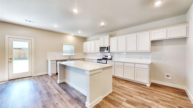 kitchen featuring appliances with stainless steel finishes, a center island, and white cabinetry