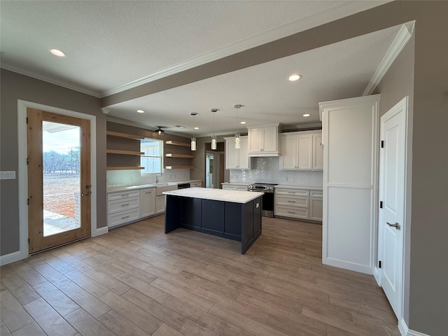 kitchen with a center island, light hardwood / wood-style flooring, hanging light fixtures, electric range, and white cabinets