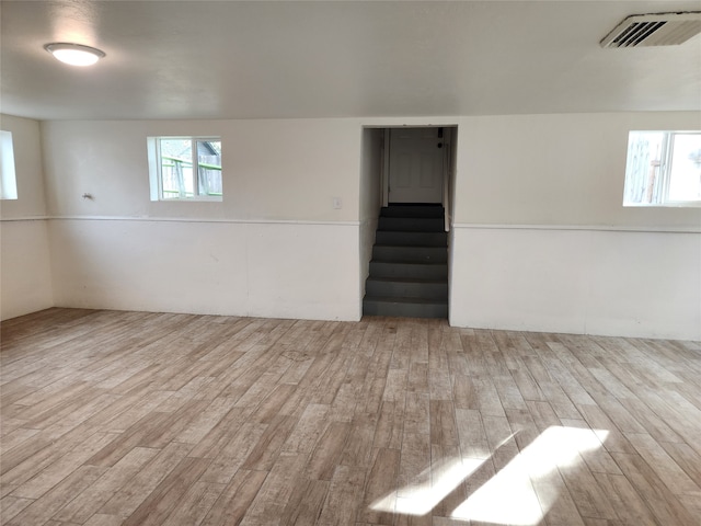 basement featuring light hardwood / wood-style flooring and a healthy amount of sunlight