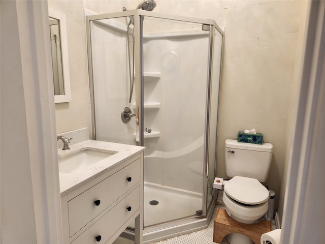 bathroom featuring tile patterned floors, vanity, toilet, and a shower with shower door