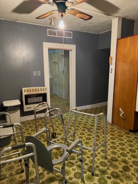 workout room with ceiling fan and wood walls