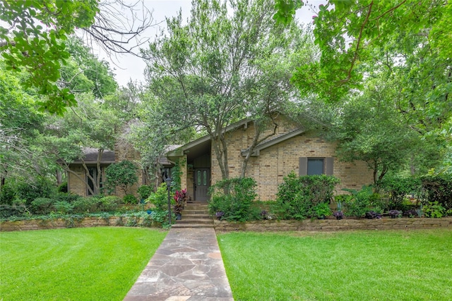 view of front of home featuring a front yard and brick siding