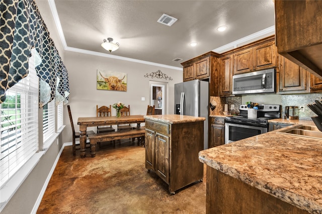 kitchen with crown molding, stainless steel appliances, backsplash, a center island, and sink