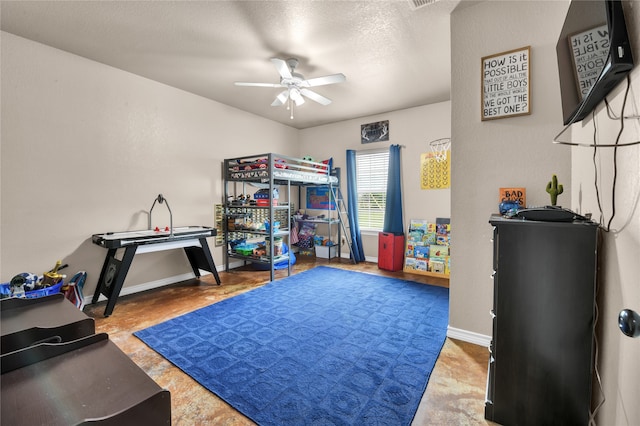 rec room featuring ceiling fan and a textured ceiling