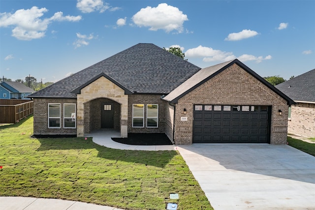 french country style house with a garage and a front yard