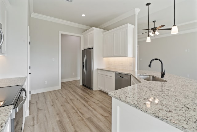 kitchen with appliances with stainless steel finishes, sink, backsplash, light hardwood / wood-style floors, and ceiling fan