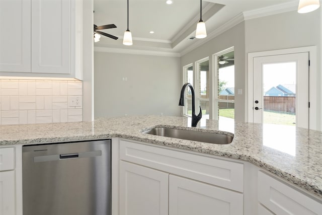 kitchen featuring decorative light fixtures, stainless steel dishwasher, ceiling fan, a tray ceiling, and white cabinets