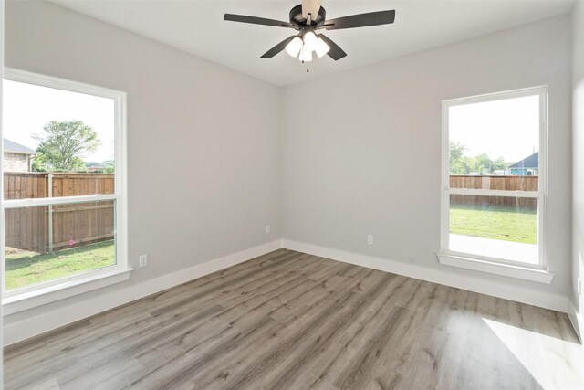 unfurnished room featuring light hardwood / wood-style flooring, a wealth of natural light, and ceiling fan