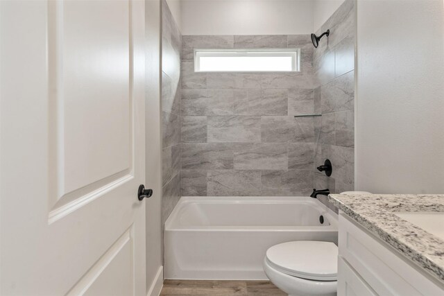 full bathroom with toilet, hardwood / wood-style floors, vanity, and tiled shower / bath