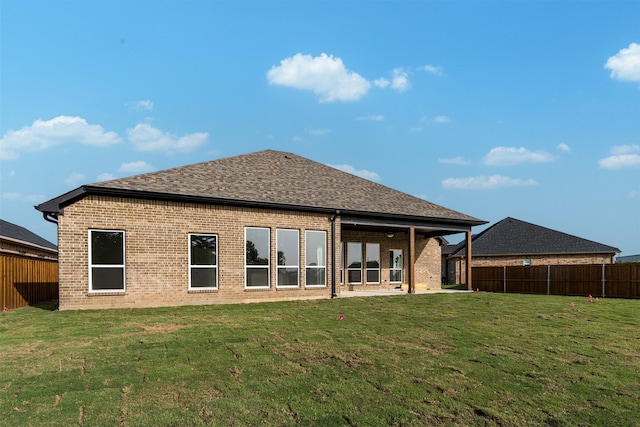 rear view of property with a lawn and a patio area