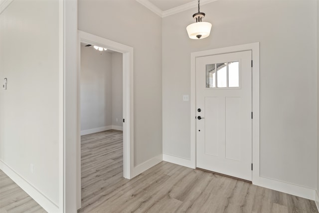 foyer entrance with light hardwood / wood-style floors and crown molding