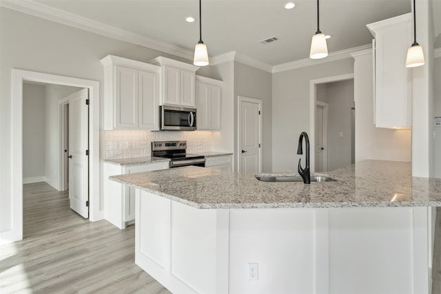 kitchen featuring white cabinetry, decorative light fixtures, tasteful backsplash, light hardwood / wood-style floors, and appliances with stainless steel finishes