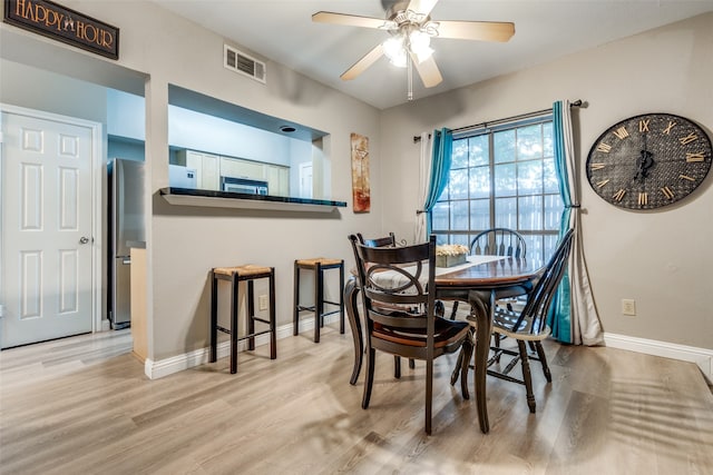 dining area with ceiling fan and light hardwood / wood-style flooring