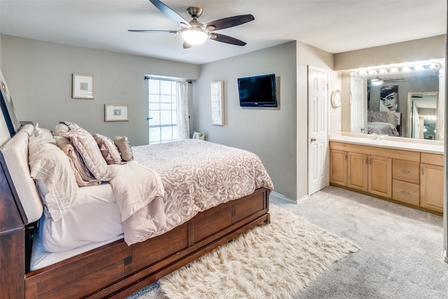 bedroom with light colored carpet, sink, ensuite bath, and ceiling fan