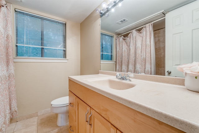 bathroom featuring tile flooring, toilet, and vanity