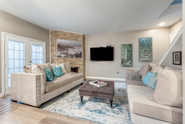 living room with wood-type flooring, french doors, and a fireplace