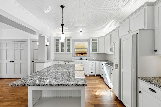 kitchen with a center island, light wood-type flooring, white appliances, white cabinets, and sink