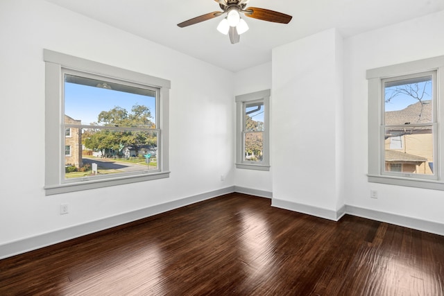 unfurnished room featuring plenty of natural light, ceiling fan, and dark hardwood / wood-style floors