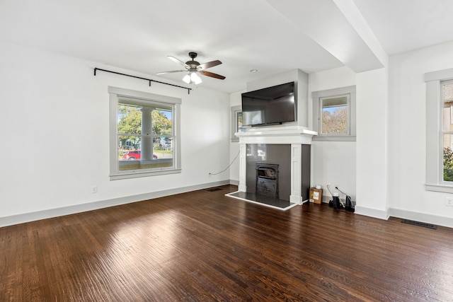 unfurnished living room with ceiling fan and dark hardwood / wood-style flooring