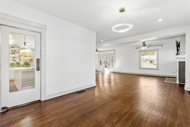 unfurnished living room featuring dark hardwood / wood-style floors, ceiling fan, and french doors